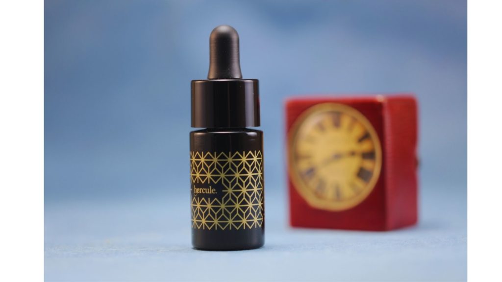 CBD oil Hercule is on a blue backdrop with a red leather clock.